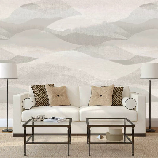Modern living room with a white sofa, decorative pillows, and glass coffee tables against a textured wall mural.