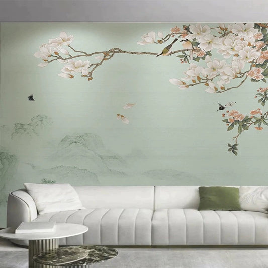 Living room with a white sofa against a wall mural featuring floral and mountain designs.
