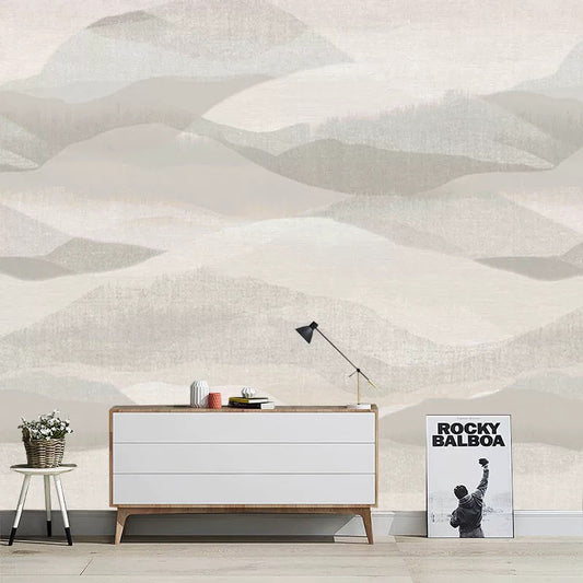 Modern interior with a white dresser, lamp, and poster against a geometric wall pattern.