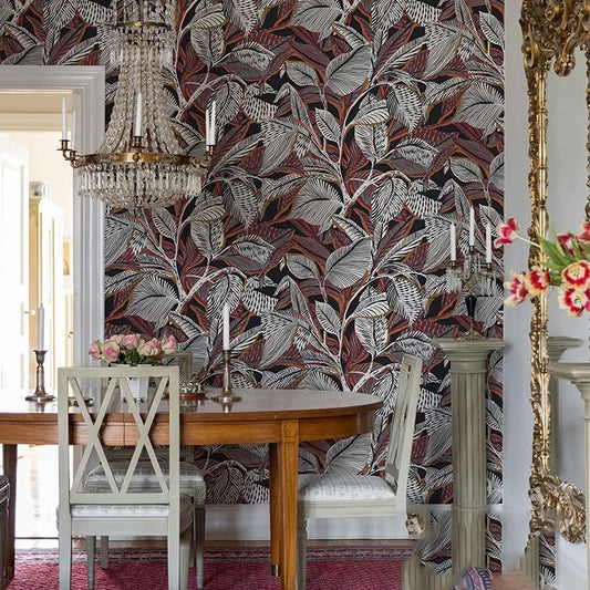 Dining room with floral-patterned wallpaper, wooden table, and chairs.