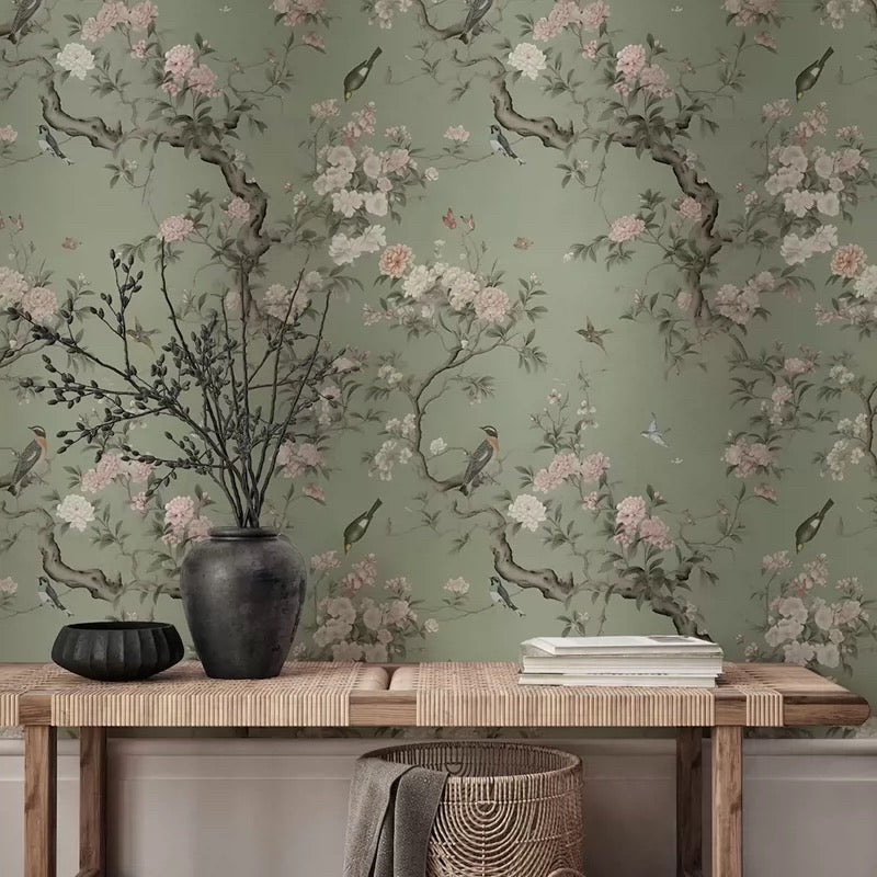 Wallpaper mural with floral and bird design on a green background, with a wooden console table and decorative items.