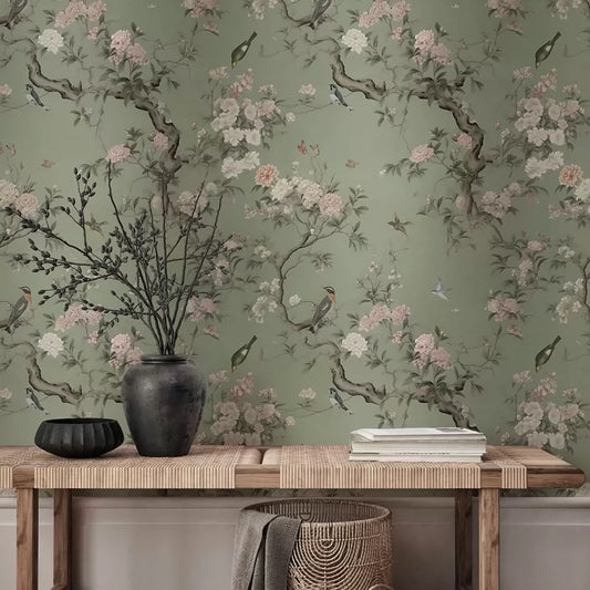 Wallpaper with floral and bird design on a green background, with a wooden console table and decorative items.