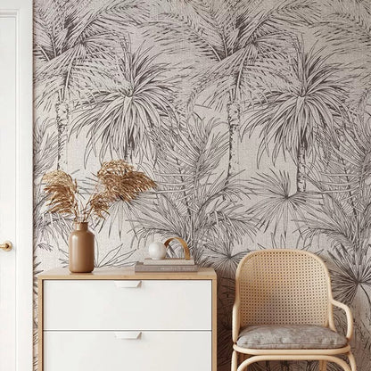 Room interior with palm leaf wallpaper, white cabinet, and wicker chair.