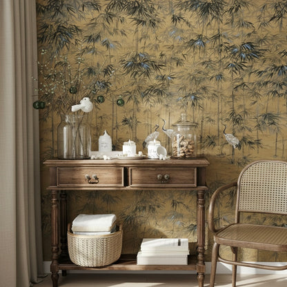 Entryway console table with candles and books styled against a textured gold bamboo mural.