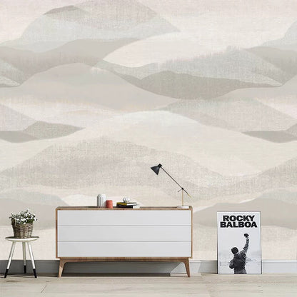 Modern interior with a white dresser, lamp, and poster against a geometric wall pattern.