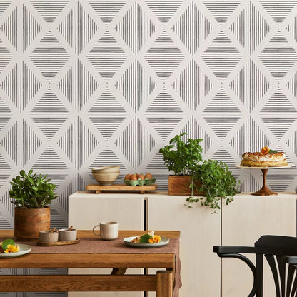 Dining room with geometric wallpaper, table, chairs, and decorative items.