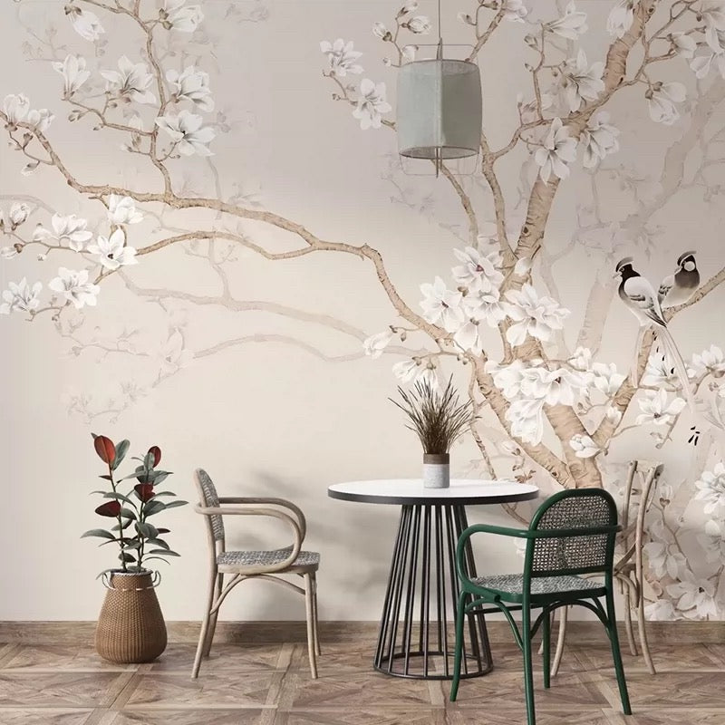 Dining area with a round table and chairs against a floral wall mural.