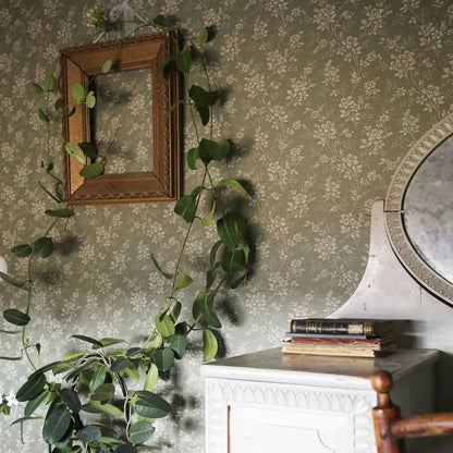Decorative wall with floral wallpaper, wooden frame, and greenery