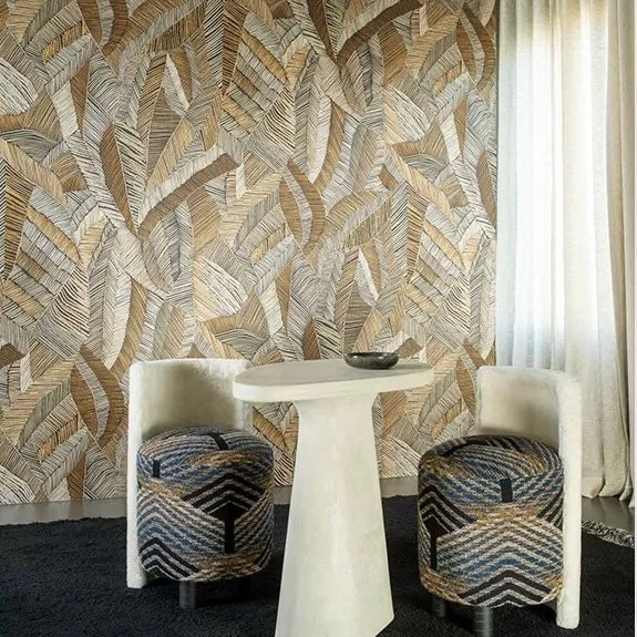 Room with leaf patterned wallpaper, white table, and patterned stools.